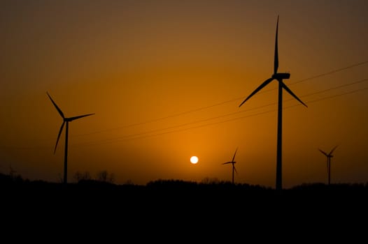 Windmill conceptual image. View on windmills during sunset.