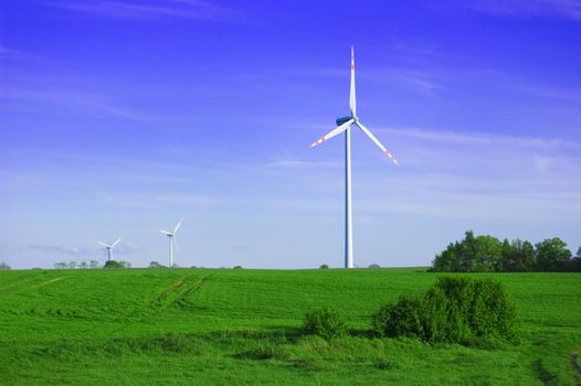 Windmill conceptual image. Windmills on the green field.