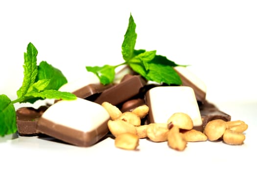 Closeup shot of some peanuts, mint leafes and chocolate
