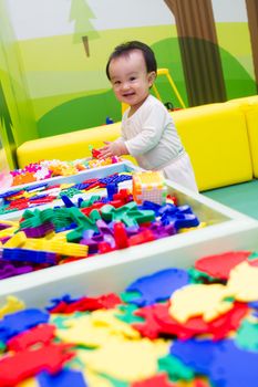 An Asian Chinese baby playing puzzle at indoor playground.