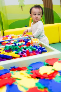 An Asian Chinese baby playing puzzle at indoor playground.