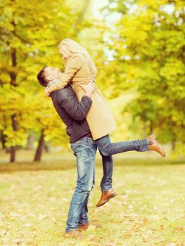 holidays, love, travel, relationship and dating concept - romantic couple playing in the autumn park