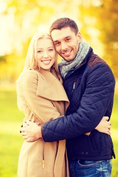 holidays, love, travel and dating concept - romantic couple in the autumn park