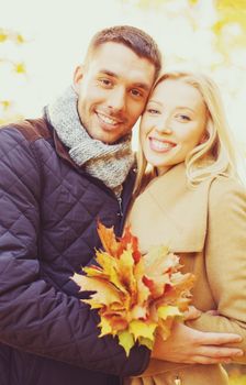 holidays, love, travel, relationship and dating concept - romantic couple in the autumn park