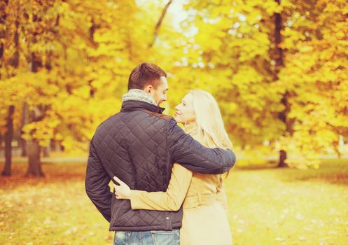 holidays, love, travel, relationship and dating concept - romantic couple kissing in the autumn park