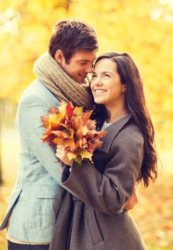 holidays, love, travel, relationship and dating concept - romantic couple kissing in the autumn park