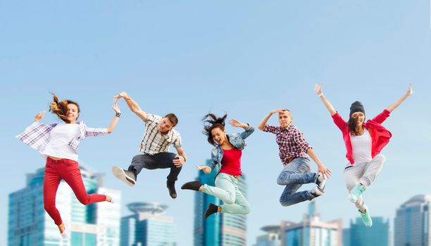 summer, sport, dancing and teenage lifestyle concept - group of teenagers jumping