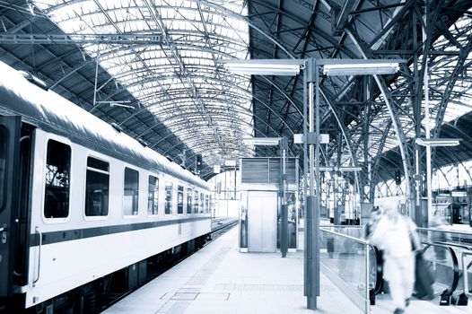 People hurrying for a train on railway station.