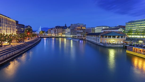 Urban view with famous fountain and Rhone river by night with full moon, Geneva, Switzerland, HDR