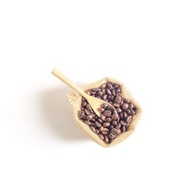 Coffee beans and wooden spoon  on sack surface.Isolated on white background.