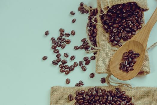 Coffee beans and wooden spoon on sack surface.Filter effect retro vintage style