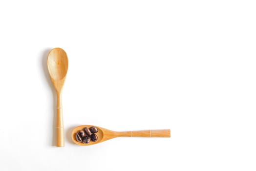 Coffee beans on wooden spoon isolated on white background.