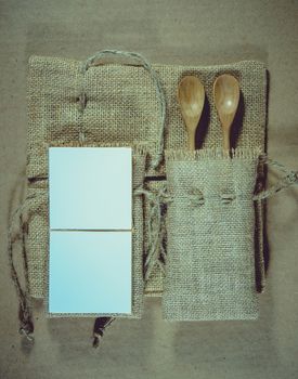 Notepad and wooden spoon on sack surface background.