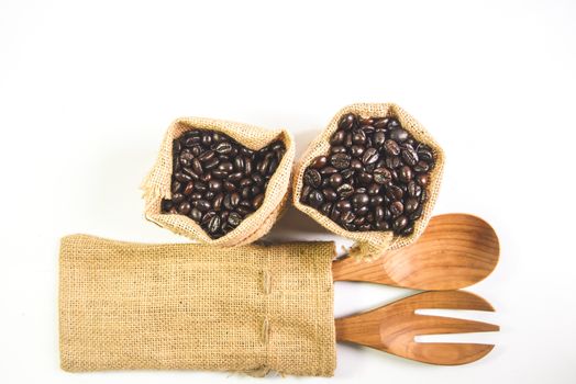 Wooden spoon and fork, Coffee beans on sack surface.Isolated on white background.