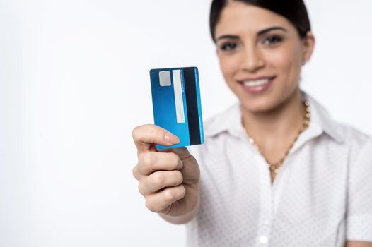 Happy woman showing credit card, focus on card.