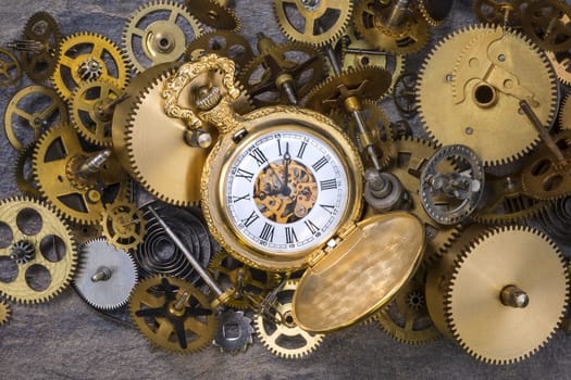 Pocket watch and a selection of dusty old brass clock parts.