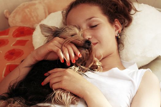 The girl embraces the puppy of the yorkshire terrier