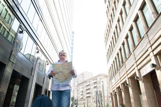 Man with blue bag lookig the way by city plan