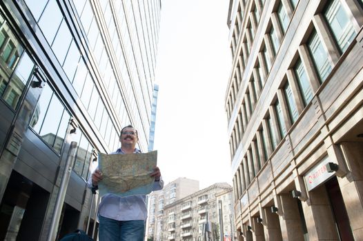 Man with blue bag lookig the way by city plan