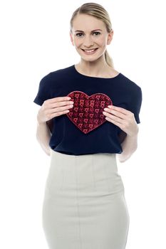 Pretty woman showing heart shaped gift box