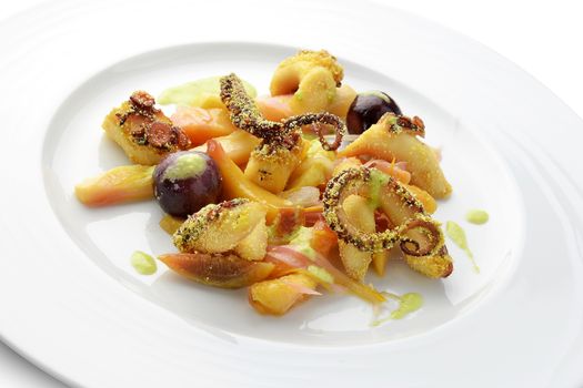 Fish Dish Fried Octopus with marinated Fruit on white roud plate