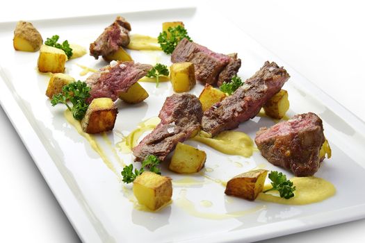 Meat Dish Cut Grilled Steak with Potatoes and Parsley on square white plate