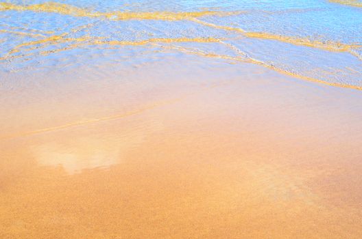 Transparent soft waves on the sandy beach