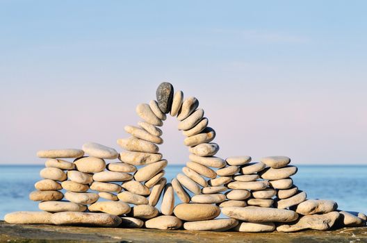 Arc of pebbles between of the stones on the seashore