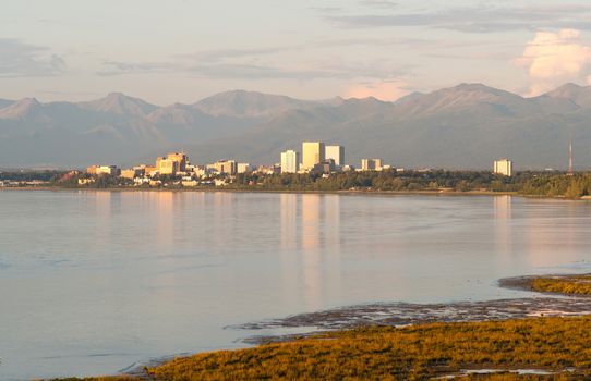 A pink sunset reflects light on the buildings and water