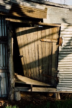 The broken timber door of a deserted building in Rural Australia.