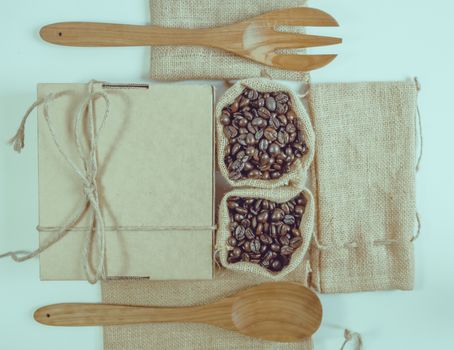 Coffee beans wooden spoon and fork on sack surface.Filter effect retro vintage style