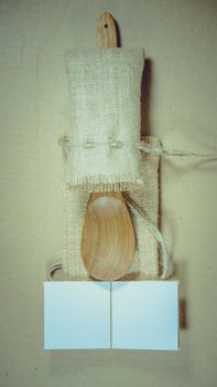 Notepad and wooden spoon on sack surface background.