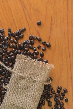 Sackcloth and coffee beans on old wooden table.top view point