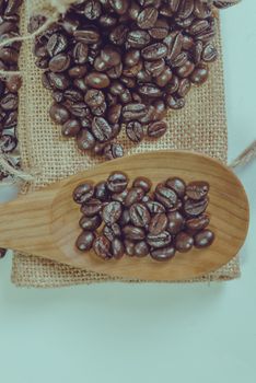 Coffee beans and wooden spoon on sack surface.Filter effect retro vintage style