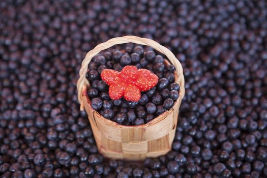 Fresh blueberries with a little basket of strawberries on the market.