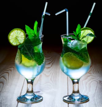 Two glass of cool mojito on a wooden table