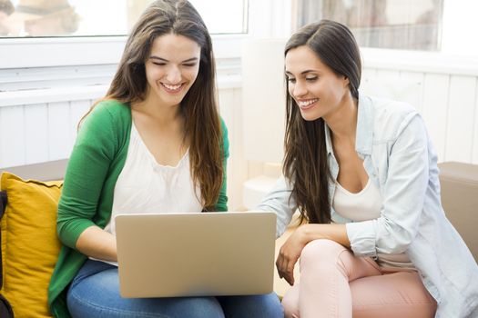 Female friends at the local coffee shop drinking coffee and working