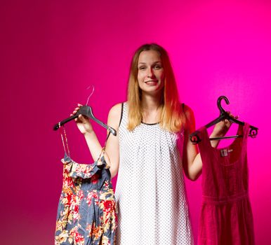 Beautiful young woman show is clothe on a pink background