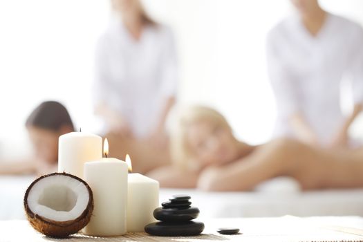 Spa massage tools and women getting massage on background