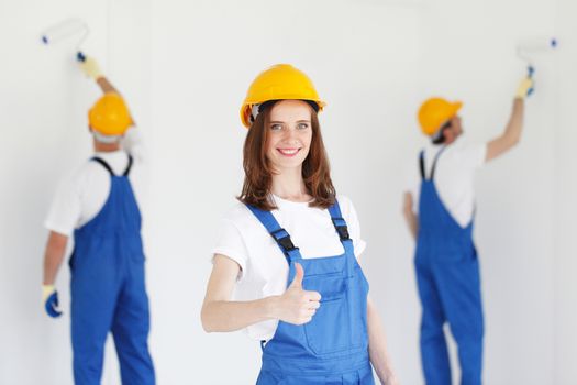 workman gives thumbs up in front of two painters