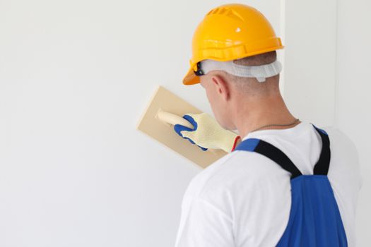 portrait of workman polishing wall