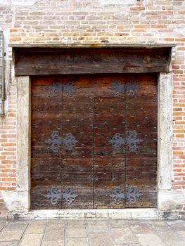 close up wooden door with brick wall building architecture in Venice, Italy