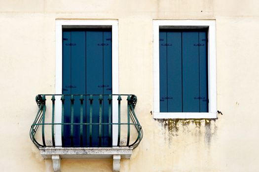 door with balcony and window on creme wall building in Venice, Italy