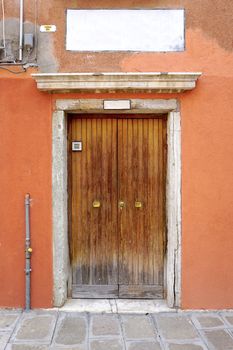 entrance wooden door of old building house in Venice, Italy