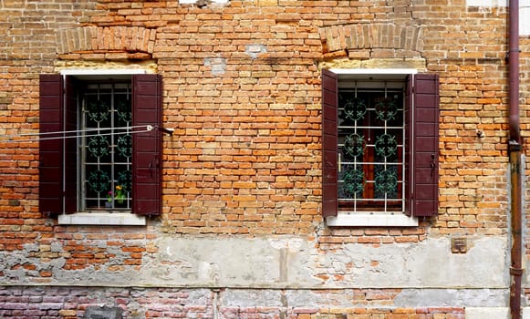 two windows with brick decay wall building in Venice, Italy