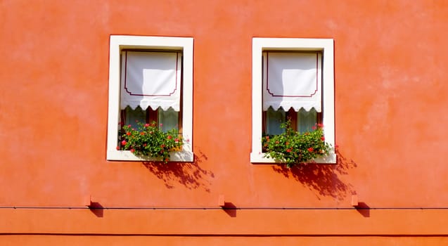 two windows with orange wall building in Venice, Italy