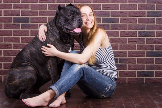 Portrait of a young girl hugging a big dog Cane Corso