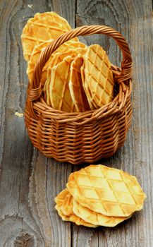 Heap of Crunchy Thin Waffles in Wicker Basket closeup on Rustic Wooden background