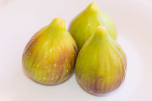 Three mature figs on white background.