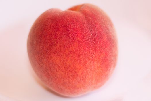 One mature peach on a white background.
